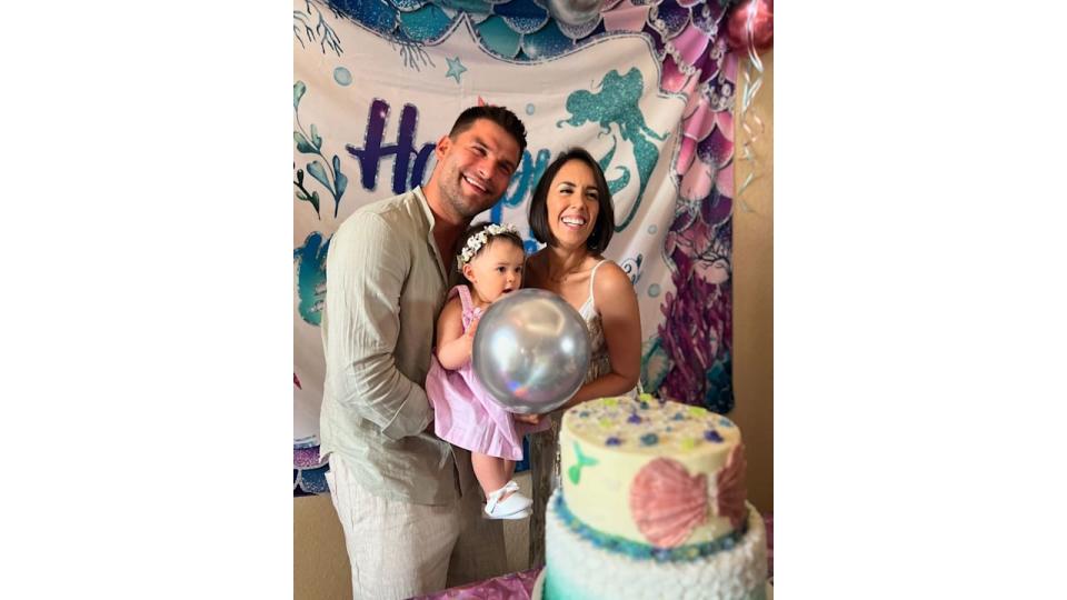 parents holding daughter at first birthday party