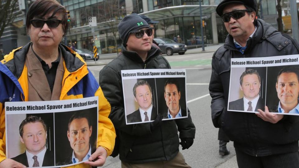 Manifestantes sostienen carteles pidiendo la liberación de Michael Spavor y Michael Kovrig