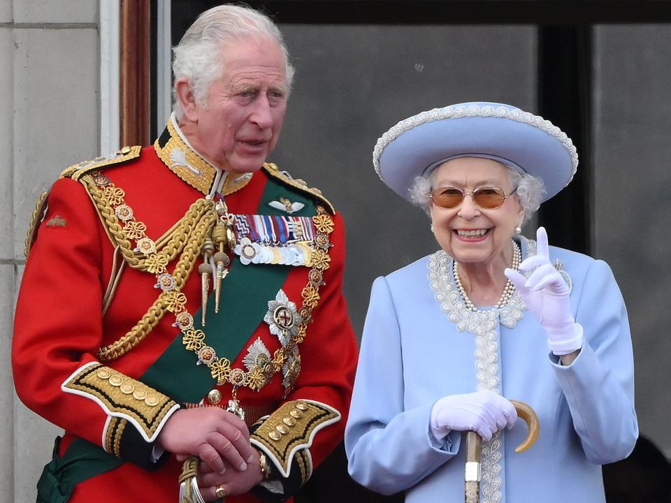 Queen Elizabeth II (R) stands with Britain's Prince Charles, Prince of Wales to watch a special flypast from Buckingham Palace.