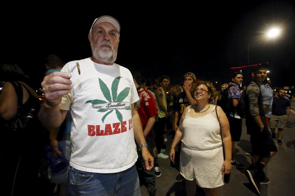 A man shows a joint to the camera as marijuana enthusiasts gather before midnight to celebrate the legalization of recreational use of marijuana in Portland, Oregon June 30, 2015. Smoking and growing small amounts of marijuana became legal in Oregon on Wednesday, as a growing legalization movement spread down the United States' west coast. A law allowing recreational use, backed by voters in November, came into effect at midnight, opening the way for marijuana to be sold in shops by next year - though some lawmakers say they will still try to block retail outlets. Picture taken June 30, 2015. REUTERS/Steve Dipaola