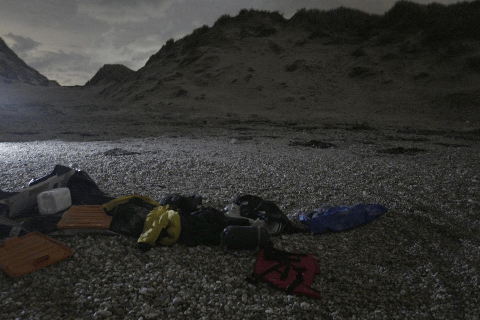 Life jackets, sleeping bags and damaged inflatable small boat are pictured early morning on the shore in Wimereux, northern France, Friday, Nov. 26, 2021 in Calais, northern France. Children and pregnant women were among at least 27 migrants who died when their small boat sank in an attempted crossing of the English Channel, a French government official said Thursday. (AP Photo/Rafael Yaghobzadeh)