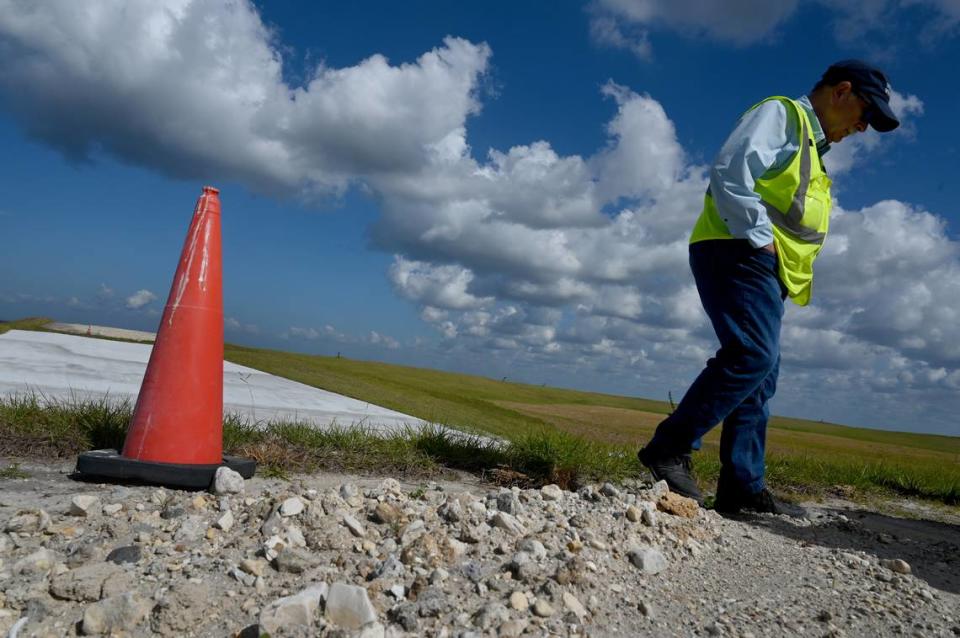 Operadores de Piney Point anunciaron recientemente un hito con el cierre del compartimento Old Gypsum Stack-South, uno de los cuatro estanques que deben cerrarse en la antigua planta de procesamiento de fosfatos. La plataforma blanca a la izquierda de Herb Donica es un dique, una rampa que impide que el agua permanezca en el estanque. En caso de fuertes lluvias, el estanque está diseñado para desbordarse más allá de la presa y llegar a una zona de recolección de aguas pluviales.