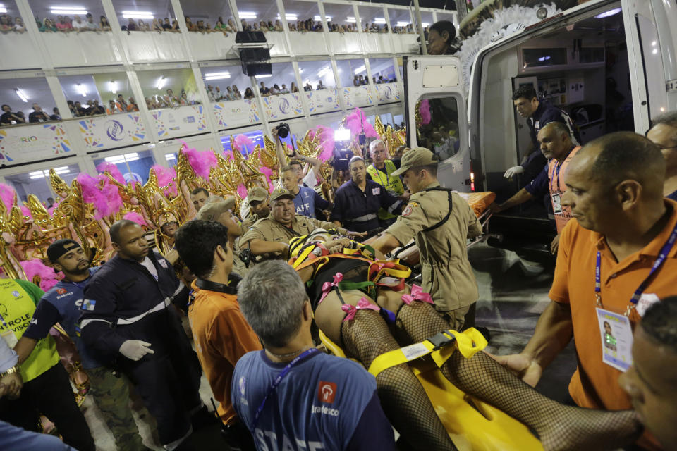 FILE - In this Feb.28, 2017 file photo, a performer from the Unidos da Tijuca samba school is carried into an ambulance after a float collapsed during Carnival celebrations at the Sambadrome in Rio de Janeiro, Brazil. After two float accidents at the Sambadrome revelers started speaking of a curse because Rio de Janeiro Mayor Marcelo Crivella skipped the opening Carnival ceremony . (AP Photo/Silvia Izquierdo, File)