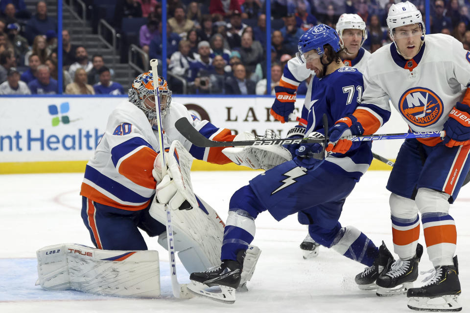 Tampa Bay Lightning's Anthony Cirelli (71) looks for a rebound from New York Islanders goaltender Semyon Varlamov as he's defended by Ryan Pulock (6) during the second period of an NHL hockey game Monday, Nov. 15, 2021, in Tampa, Fla. (AP Photo/Mike Carlson)