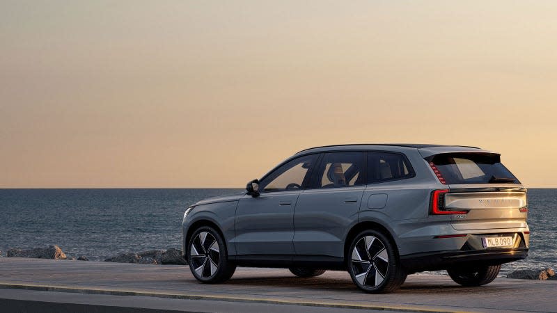 A photo of a Volvo EX90 electric SUV by the sea. 