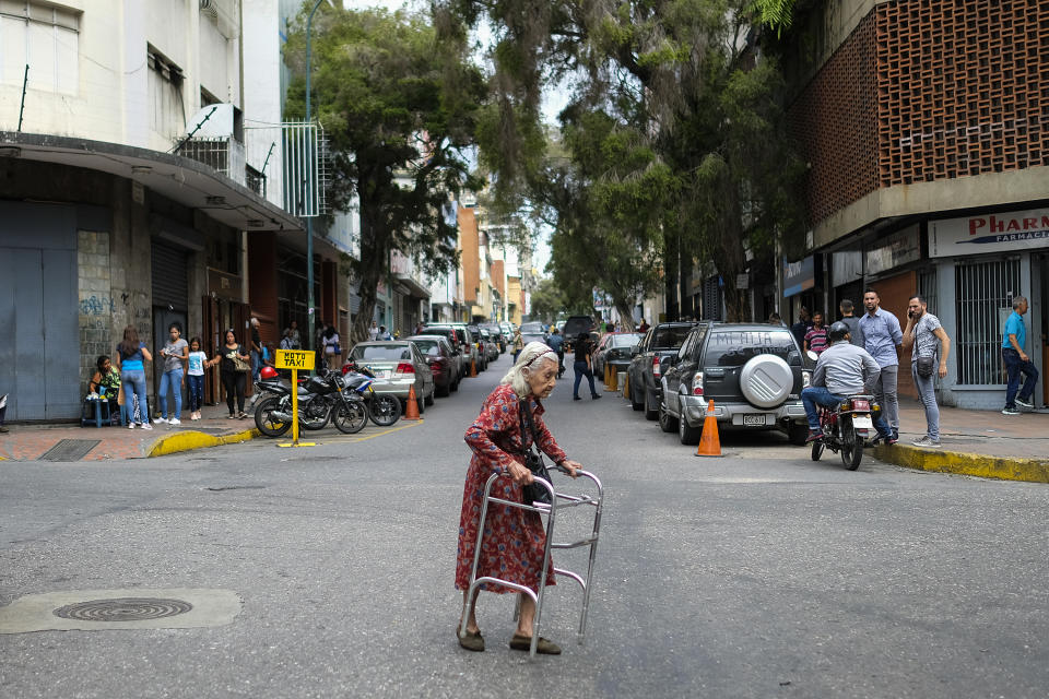 An elderly woman crosses a street in Caracas on July 22, 2019. - Venezuela is wracked by an economic crisis after five years of crippling recession in which its population has faced many hardships such as a shortage of basic necessities and failing public services. (Photo by Matias Delacroix / AFP)        (Photo credit should read MATIAS DELACROIX/AFP via Getty Images)