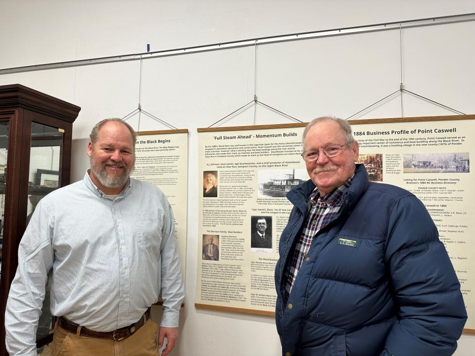 Relatives of steamboat owner A.J. Johnson, Amos McLamb, right, and Joshua Scott McLamb, left, posed next to an exhibit panel that shares information about Johnson. Amos McLamb is the grandson of Johnson and Joshua Scott McLamb is the great grandson of Johnson.