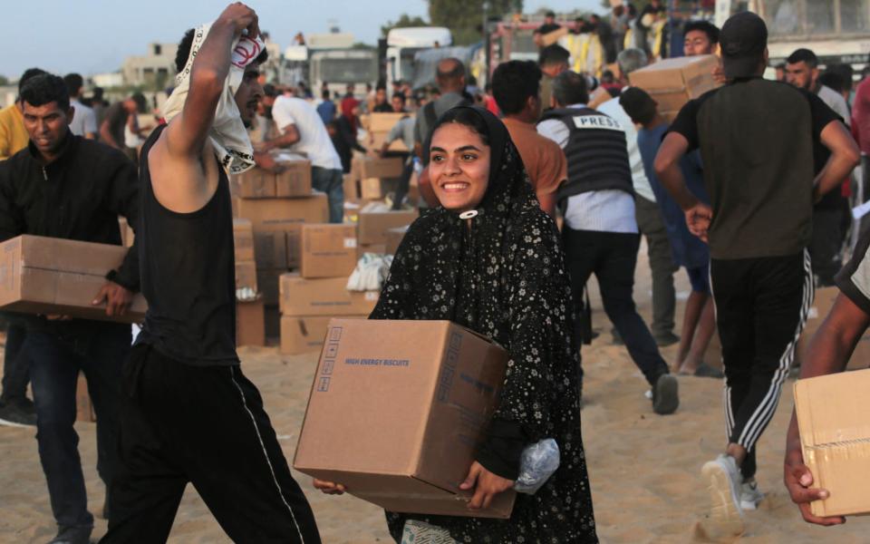 A woman receives a box of humanitarian aid near Nuseirat in the central Gaza Strip