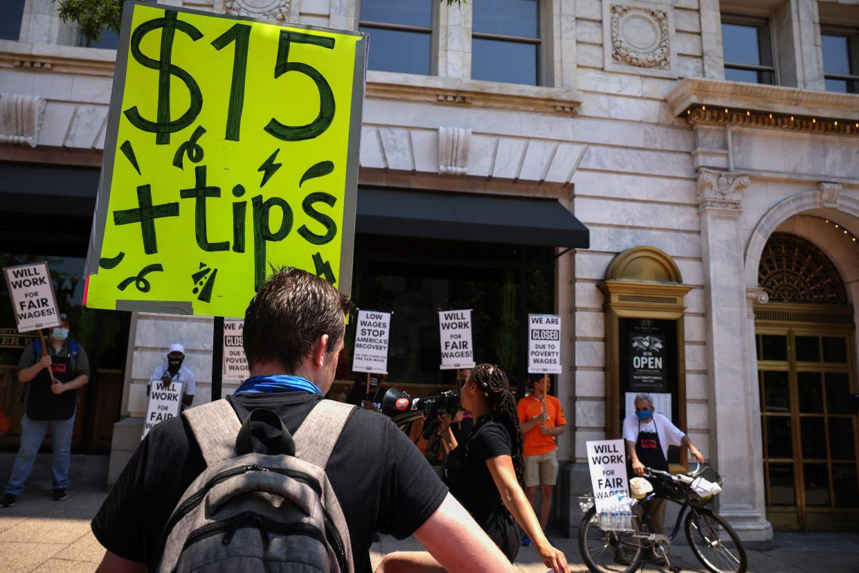 An activist holds a sign up outside Old Ebbitt Grill restaurant during a “Wage Strike” demonstration on May 26th, 2021 in Washington, DC. Delaware lawmakers have voted to give final approval to raising the state’s minimum wage to $15 an hour. (Getty Images)