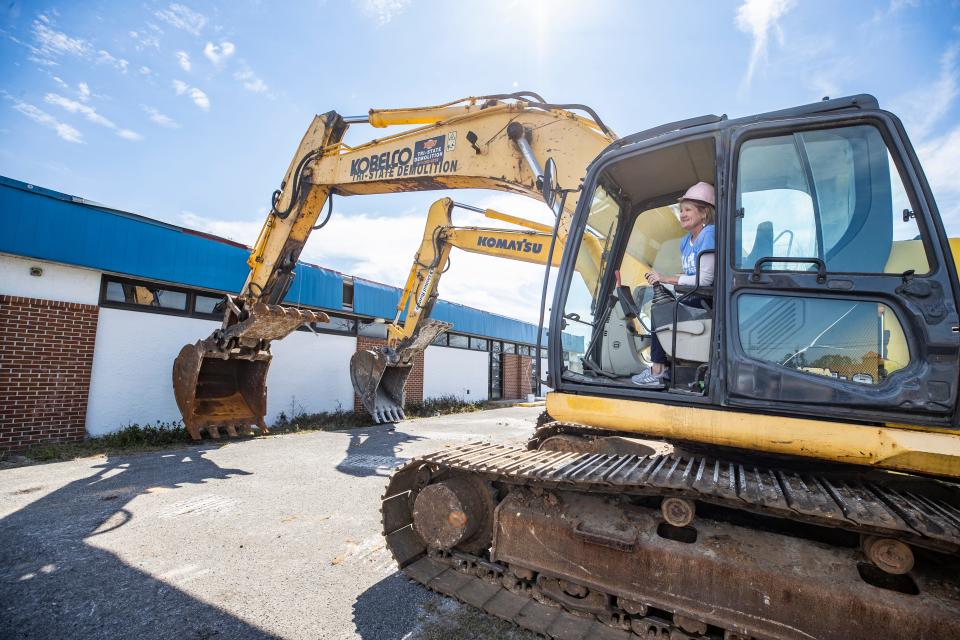 Haney Technical College Director Ann Leonard gets final instructions before taking the controls to knock down a wall at the old nursing building on campus on March 3.