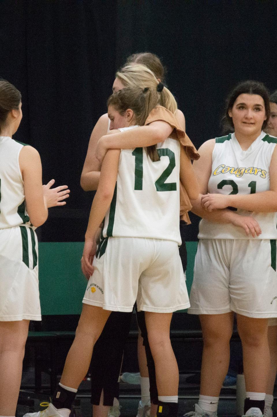 WCA head coach Kennedy Chesney and the team gather around to comfort Clemmie Gadwood as she steps off the court at Will Carleton for the final time in her career.