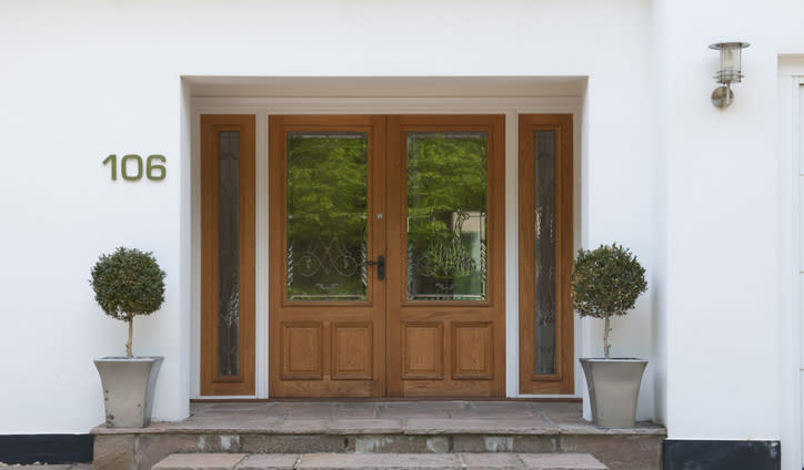 A pair of bay trees in front of a door