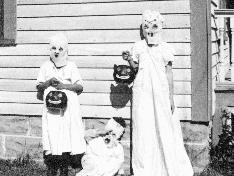 Kids circa 1925 dressed as ghosts ready to trick-or-treat.