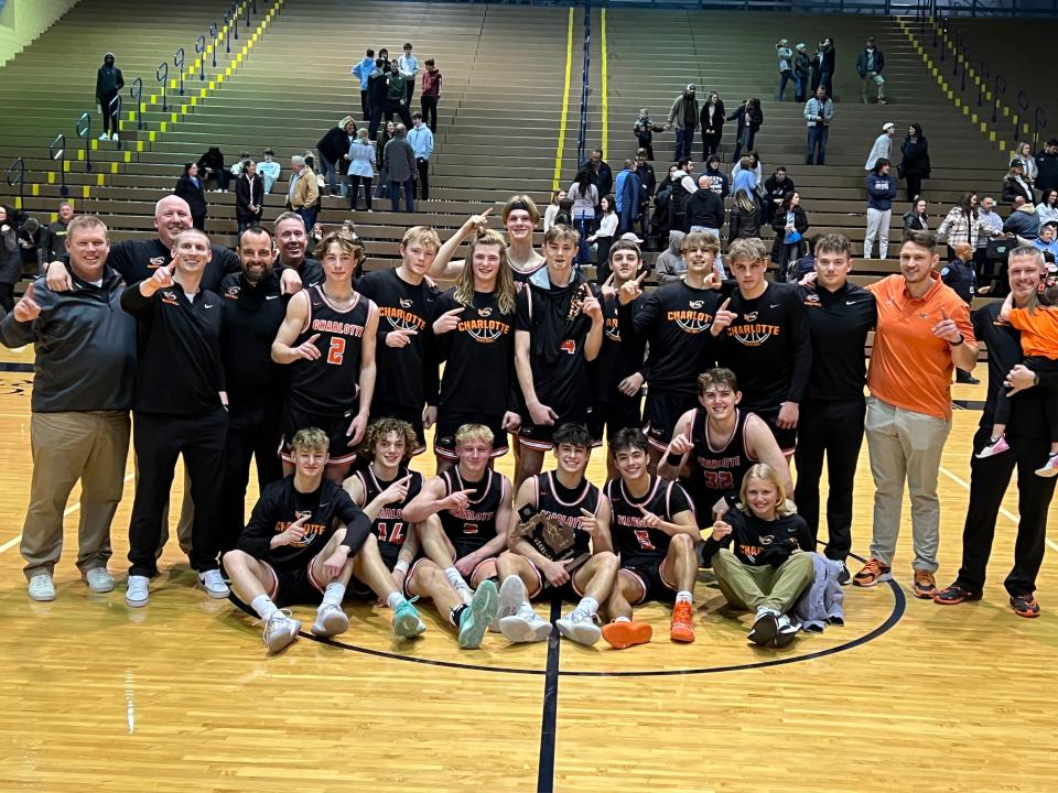 The Charlotte boys basketball poses with the trophy after winning a Division 2 district championship on March 10, 2023, after beating Lansing Catholic, 70-68, at Don Johnson Fieldhouse.
