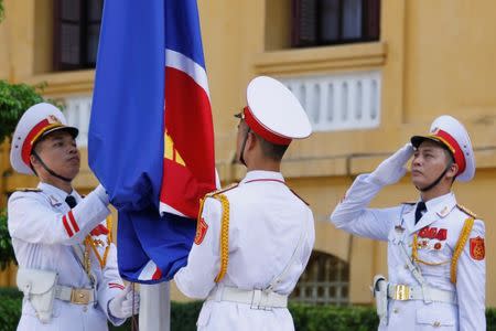 Honour guards raise an Association of Southeast Asian Nations (ASEAN) flag at a flag-raising ceremony to mark the 50th anniversary of the regional group at Vietnam's Ministry of Foreign Affairs in Hanoi August 8, 2017. REUTERS/Kham