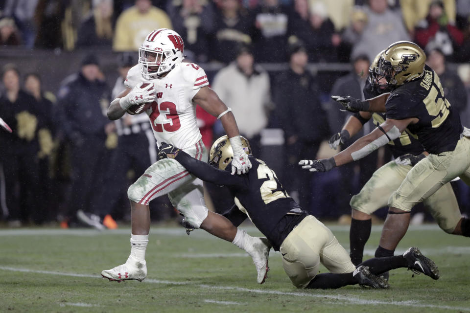 FILE - In this Saturday, Nov. 17, 2018, file photo, Wisconsin running back Jonathan Taylor (23) breaks the tackle of Purdue safety Navon Mosley (27) on his way to scoring a game-winning touchdown during overtime of an NCAA college football game in West Lafayette, Ind. The sophomore is a finalist for a second straight year for the Doak Walker Award, given to the nation’s best running back. He’s 131 yards short of his first 2,000-yard season as the Badgers get ready to play Minnesota this weekend in the annual rivalry game for Paul Bunyan’s Axe. (AP Photo/Michael Conroy, File)