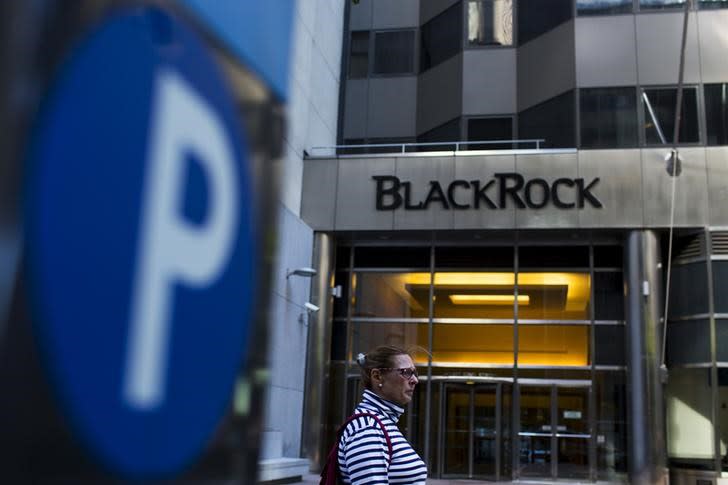 A woman walks next to a BlackRock sign pictured in the Manhattan borough of New York, October 11, 2015. REUTERS/Eduardo Munoz