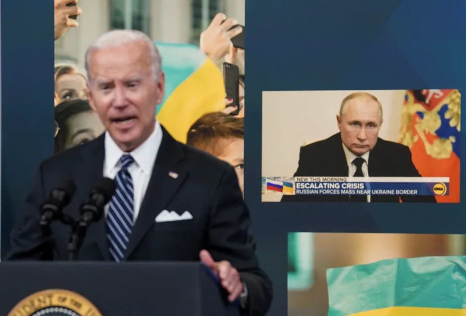 Russia's President Vladimir Putin is seen on a display in the background as U.S. President Joe Biden speaks about 