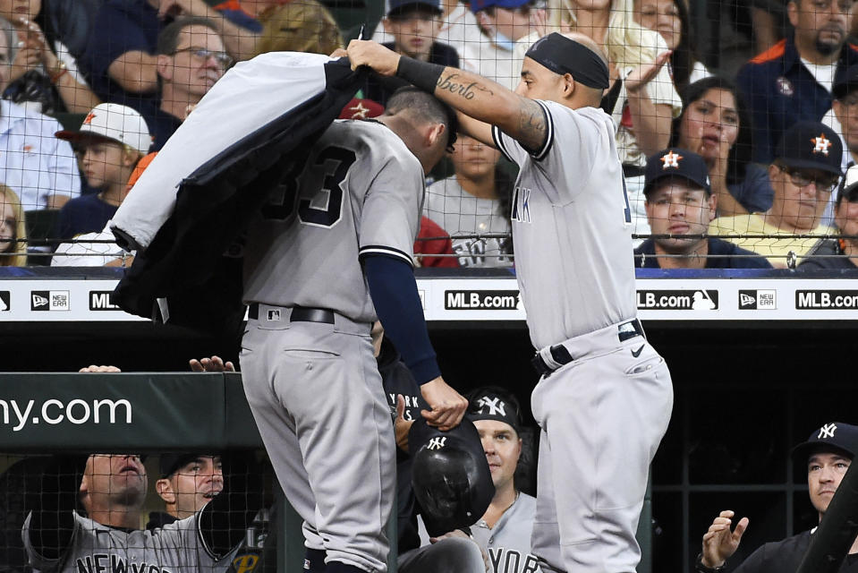 New York Yankees' Rougned Odor, right, puts a jacket on Tim Locastro after Locastro hit a solo home run during the fourth inning of a baseball game against the Houston Astros, Sunday, July 11, 2021, in Houston. (AP Photo/Eric Christian Smith)