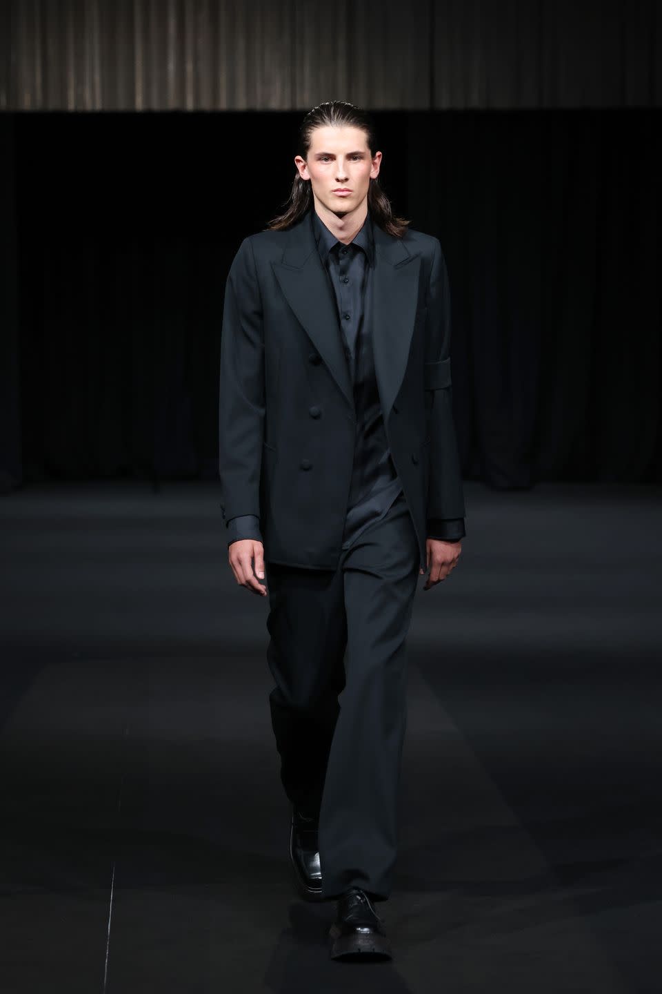 <p>Daniel W.Fletcher opened London Fashion Week by holding a minute's silence in honour of the Queen, before revealing his opening look: a model wearing a black morning suit with a singular armband in a solemn tribute. </p>