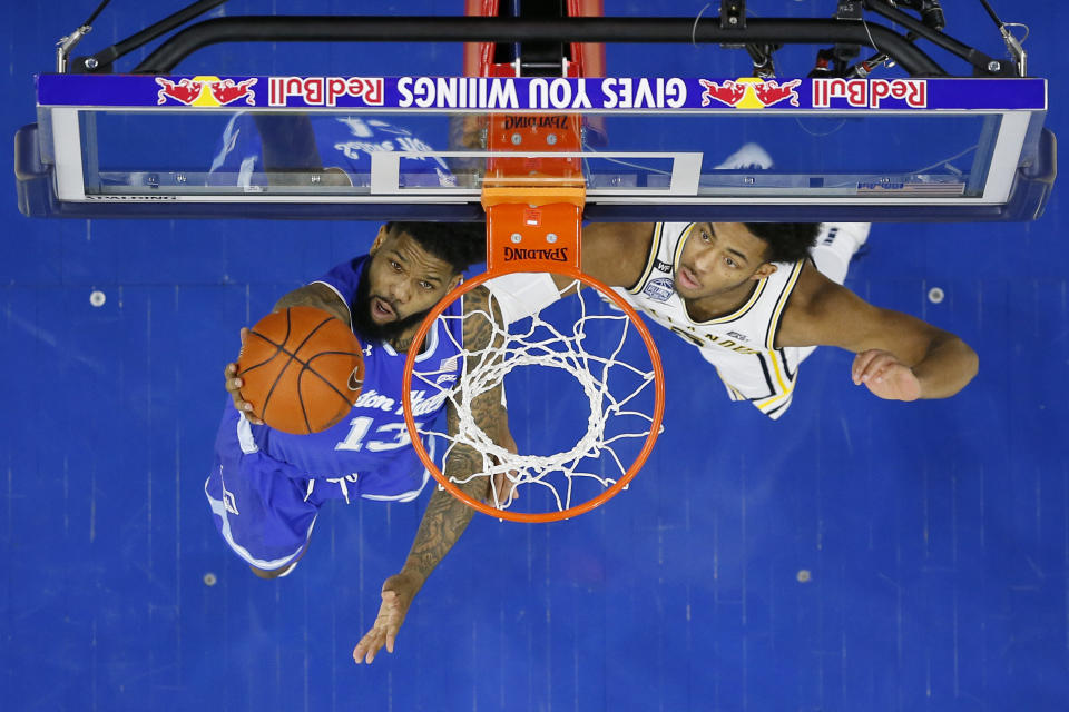 Seton Hall's Myles Powell, left, goes up for a shot past Villanova's Justin Moore during the first half of an NCAA college basketball game, Saturday, Feb. 8, 2020, in Philadelphia. (AP Photo/Matt Slocum)