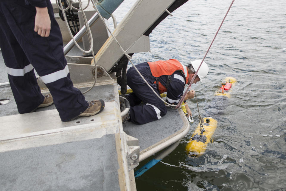 Ben Pelletier, marine operations engineer for Bluefin Robotics, attempts to retrieve a submarine in Quincy, Mass., Wednesday, April 9, 2014. Bluefin Robotics shipped a version of their submarine to help locate the missing Malaysian Airlines Flight 370, by using its side-scan sonar. (AP Photo/Scott Eisen)