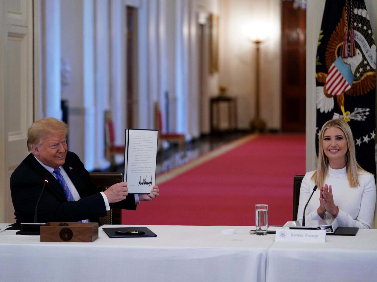 Ivanka Trump, right, applauds as President Trump holds a signed executive order during a meeting with the American Workforce Policy Advisory Board, in June. A new White House-backed ad campaign aims to encourage people who are unemployed or unhappy in their jobs or careers to "find something new": AP Photo/Evan Vucci, File