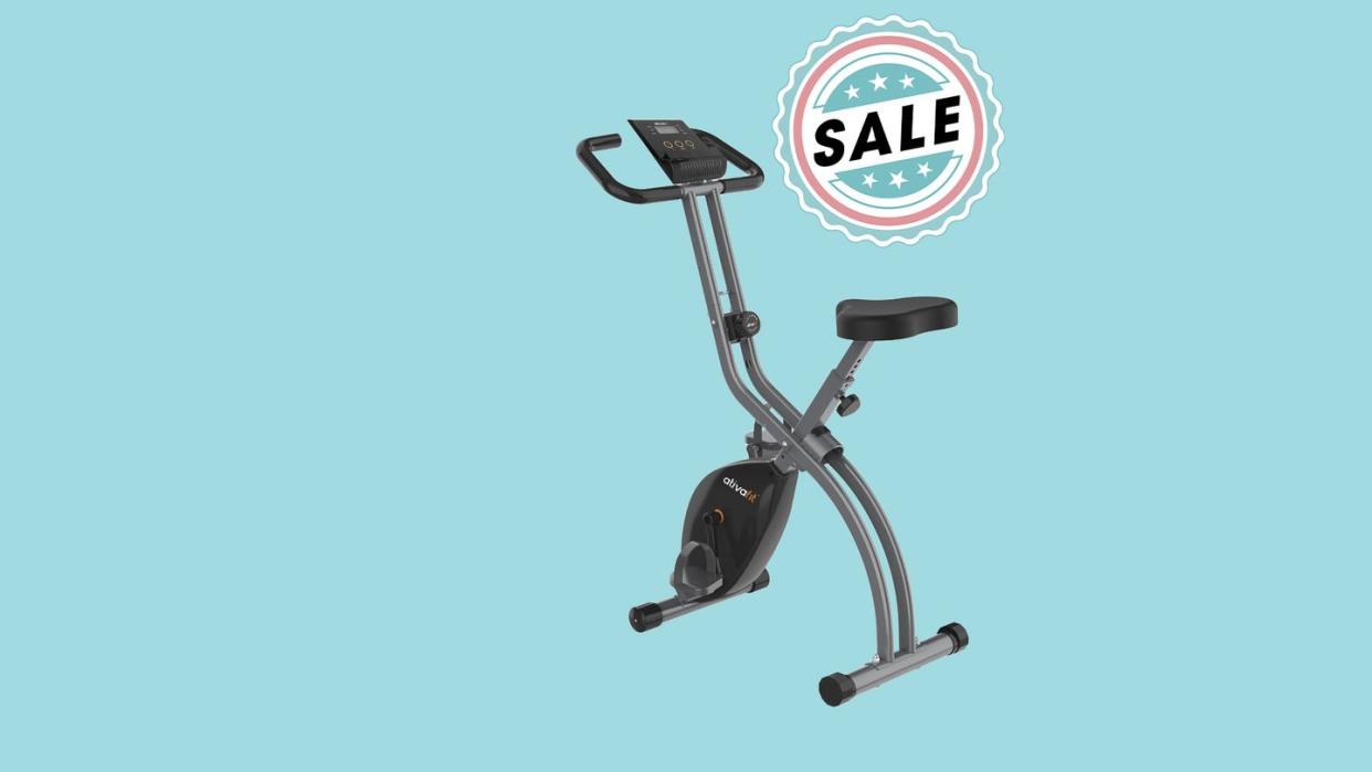 a stationary exercise bicycle with a sale sign in front of a blue background