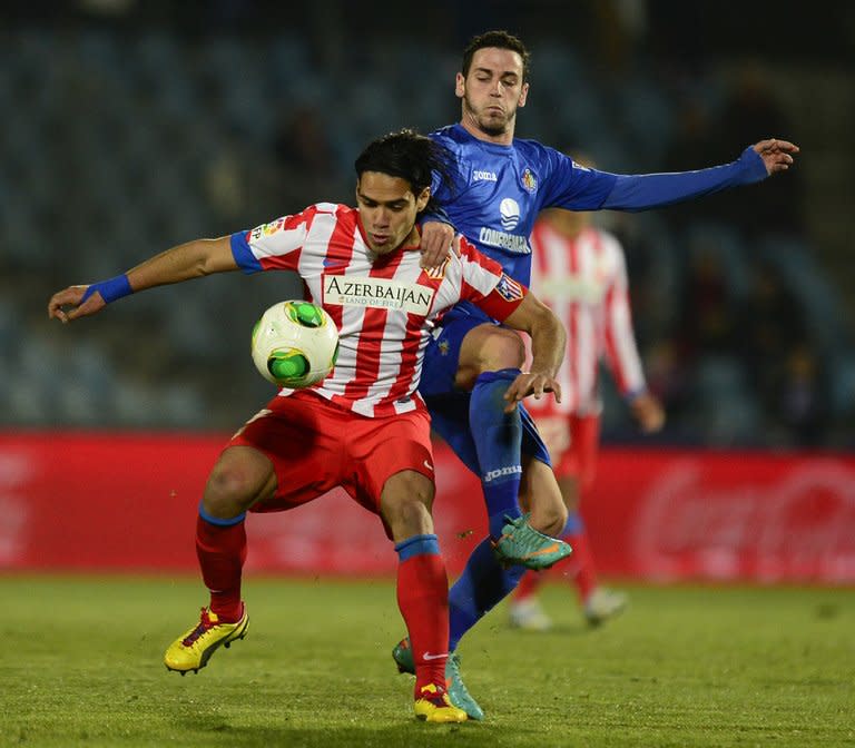 Atletico Madrid's Radamel Falcao (L) fights for the ball with Getafe's Alvaro Vazquez during their Spanish Copa del Rey match at the Coliseum Alfonso Perez stadium in Getafe, on January 10, 2013. Atletico return to La Liga competition on Sunday when they host Zaragoza