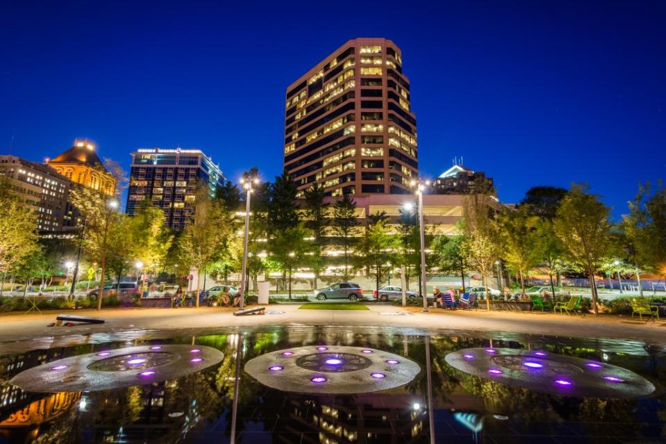 Fountains and buildings at Lebauer Park at night, in downtown Greensboro, North Carolina via Getty Images