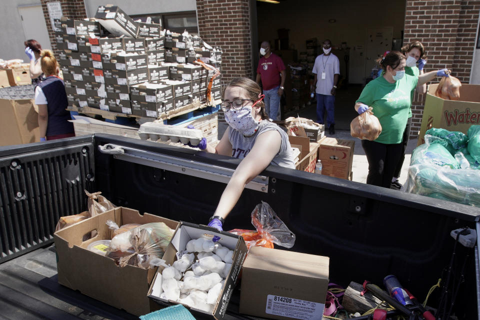 Together Omaha food pantry workers load supplies into a vehicle driving up to the pantry in Omaha, Neb., Thursday, April 23, 2020. The number of Nebraska residents seeking unemployment benefits for the first time dropped again last week but is still far higher than usual as businesses struggle with the fallout from the coronavirus. The state received 12,340 new unemployment claims during the week that ended April 18, according to the U.S. Department of Labor. (AP Photo/Nati Harnik)