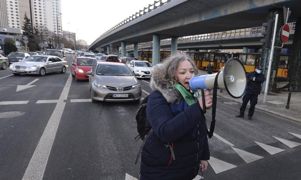 Marta Lempart, a leader of Polish Women's Strike, uses a megaphone to address protesters who gathered for a protest, on International Women's Day in Warsaw, Poland, Monday March 8, 2021. Women’s rights activists in Poland marked International Women’s Day on Monday caught between reasons to celebrate and a heavy sense that they are facing a long battle ahead. This year’s Women’s Day, which is being marked with protests, comes after a near total ban on abortion took effect in January in the historically Roman Catholic country, a step that had long been been sought by the conservative ruling party, Law and Justice. (AP Photo/Czarek Sokolowski)