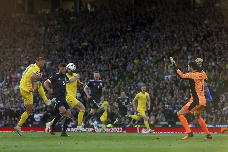 Ukraine's Andriy Yarmolenko, left, scores his side's opening goal during the World Cup 2022 qualifying play-off soccer match between Scotland and Ukraine at Hampden Park stadium in Glasgow, Scotland, Wednesday, June 1, 2022. (AP Photo/Scott Heppell)