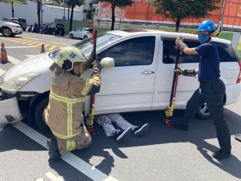 ▲台南市北區海安路與和緯路二段路口，今（10）日下午2點多發生一起車禍，轎車與機車擦撞後，機車後座女乘客竟卡進車底動彈不得，警消出動千斤頂才把人救出。（圖／翻攝畫面）