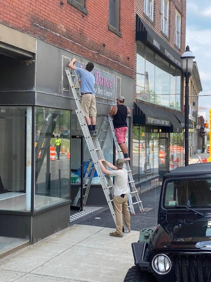 Friends of Just Dance! Performing Arts Center owner Rebecca Wilson help remove the studio's sign after the business' last day in the Ryan Block building in downtown Gardner.