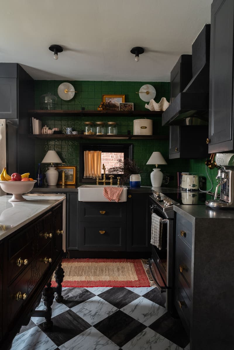 Kitchen with black cabinets and green backsplashes.