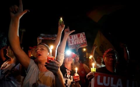 Supporters of the former president hold a vigil outside a police station in Curitiba - Credit: Reuters