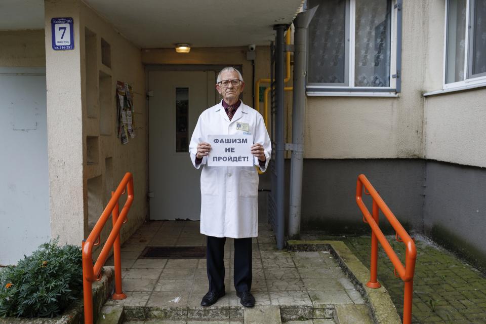 Vital Ravinski, 75, poses for a photo holding a poster reads "Fascism will not pass" at an entrance of his apartment building in Minsk, Belarus, Saturday, Sept. 12, 2020. Ravinski, a 75-year-old former doctor, attended some protests together with his granddaughters, aged 17 and 29. "I come out to protest so that my children and grandchildren have a good life," he said. "By joining the protests, I show that everyone can do it without any fear." (AP Photo)