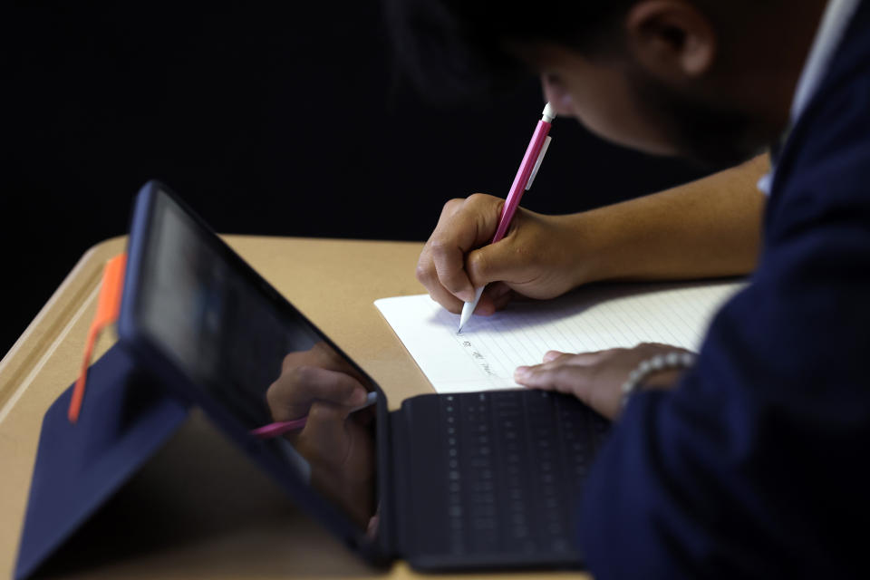 Audible Miranda Cambron takes notes as he prepares for the digital SAT, Wednesday, March 6, 2024, at Holy Family Cristo Rey Catholic High School in Birmingham, Ala. (AP Photo/Butch Dill)