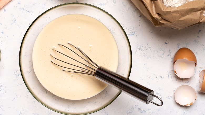 Raw batter in glass bowl with whisk