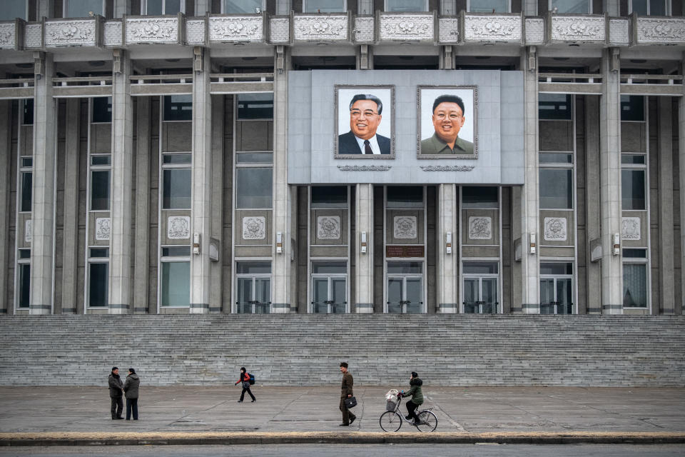 Portraits of Kim Il Sung and Kim Jong Il hang from Hamhung Grand Theatre as people pass on Feb. 3, in Hamhung, North Korea.