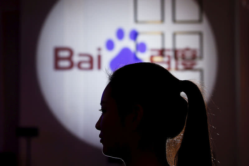 A woman is silhouetted against the Baidu logo at a new product launch from Baidu, in Shanghai, China, November 26, 2015. REUTERS/Aly Song/File Photo