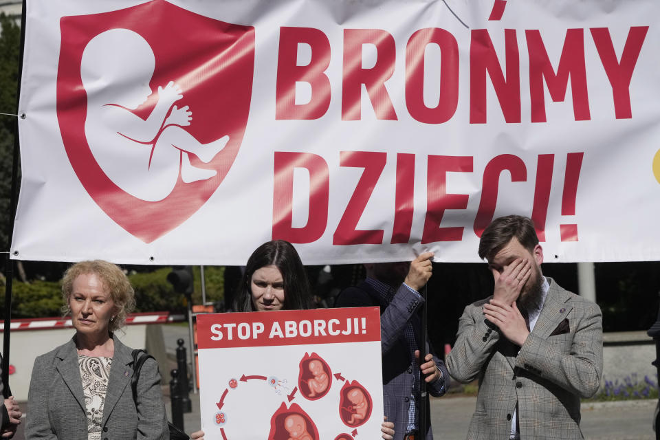 Anti-abortion activists hold a demonstration with a sign that says "We defend children" as the Polish parliament debates liberalizing the abortion law, in Warsaw, Poland, on Thursday April 11, 2024. The traditionally Catholic nation has one of the most restrictive laws in Europe — but the reality is that many women terminate pregnancies at home with pills mailed from abroad. (AP Photo/Czarek Sokolowski)