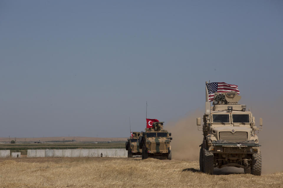 Turkish and American forces conduct their first joint ground patrol in the so-called "safe zone" on the Syrian side of the border with Turkey, seen in the background, near Tal Abyad, Syria, Sunday, Sept. 8, 2019. Turkey hopes the buffer zone, which it says should be at least 30 kilometers (19 miles) deep, will keep Syrian Kurdish fighters, considered a threat by Turkey but U.S. allies in the fight against the Islamic State group, away from its border. (AP Photo/Maya Alleruzzo)