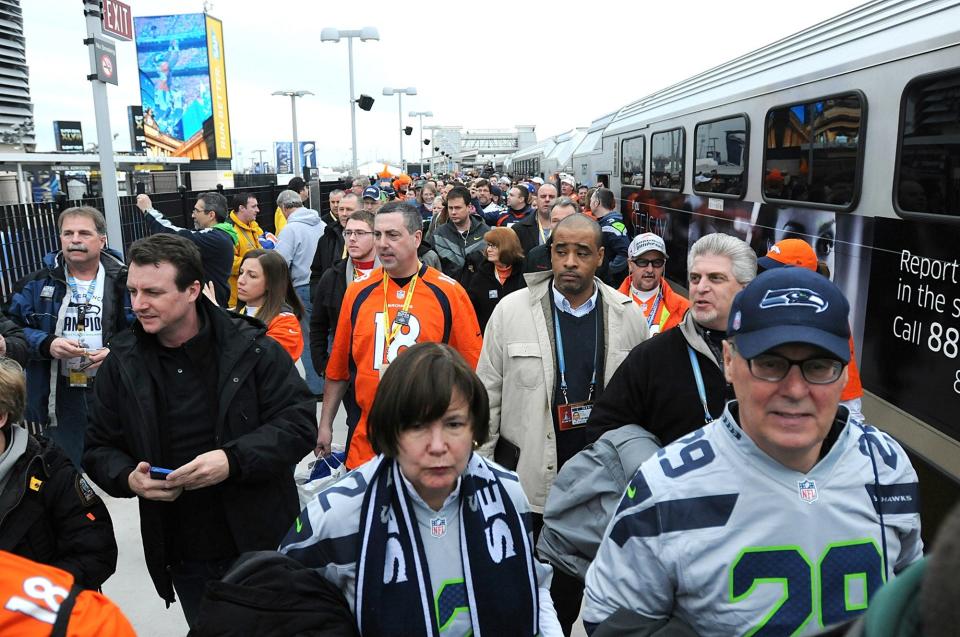 Passengers get off a NJ Transit train, which is the first train to arrive  at Meadowlands Station, on the way to the Super Bowl at MetLife Stadium in East Rutherford, February 2, 2014.