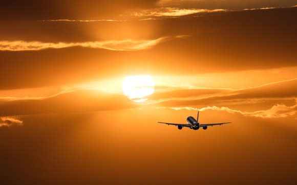 A plane taking off into the sunset.