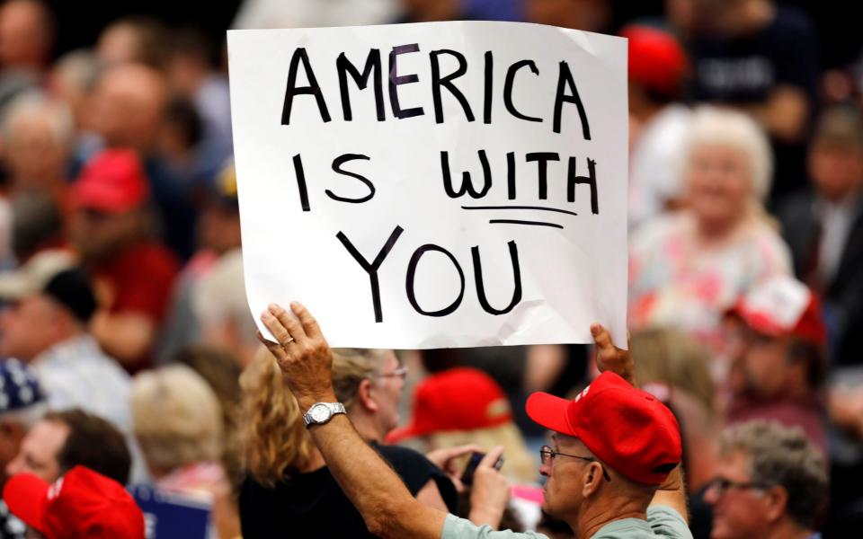 A supporter holds a sign during a rally with President Donald Trump at the U.S. Cellular Center in Cedar Rapids, Iowa - Credit: Reuters