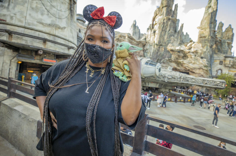 ANAHEIM, CALIFORNIA - MAY 21: In this handout photo provided by Disneyland Resort, Grammy Award-winning recording artist Lizzo, poses with Baby Yoda in front of the Millennium Falcon in Star Wars: Galaxy's Edge at Disneyland Park on May 21, 2021 in Anaheim, California.  (Photo by Christian Thompson/Getty Images via Disneyland Resort)