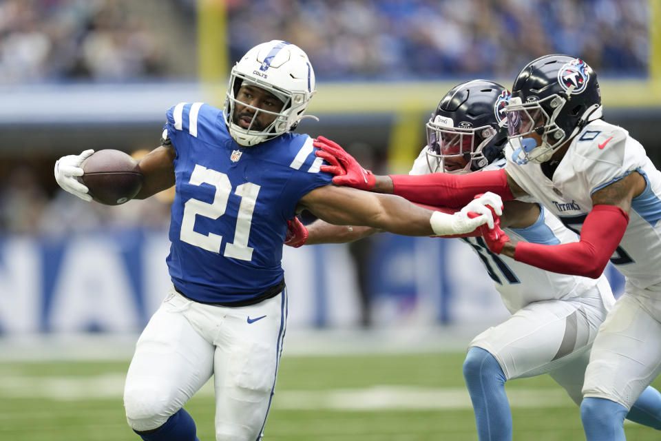 Indianapolis Colts running back Zack Moss (21) runs past Tennessee Titans safety Kevin Byard, center, and cornerback Sean Murphy-Bunting, right, during the second half of an NFL football game, Sunday, Oct. 8, 2023, in Indianapolis. (AP Photo/Michael Conroy)