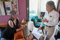 Dr. Amy Attas, right, goes over Puddy Beyer, a 19 year old male Domestic Short Haired cat's care with his human Wendy Beyer during a house call, Tuesday, April 23, 2024, in New York. (AP Photo/Mary Altaffer)